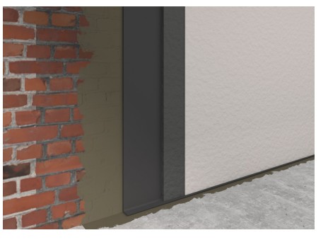 Een close-up van een muurhoek laat het contrast zien tussen een rode bakstenen sectie en een glad, lichtgekleurd gepleisterd oppervlak. Een verticale donkere metalen strip met waterafdichting scheidt de twee texturen, terwijl een betonnen vloer gedeeltelijk zichtbaar is.